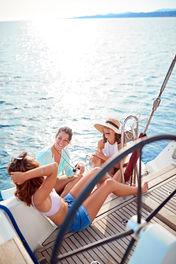 Group of friends sitting at the stern of a sailboat