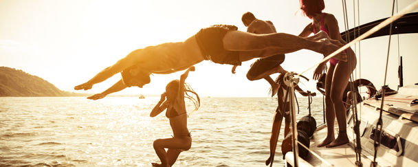 People jumping from a sailboat