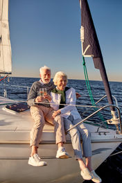 Senior couple sitting at the bow of a sailboat