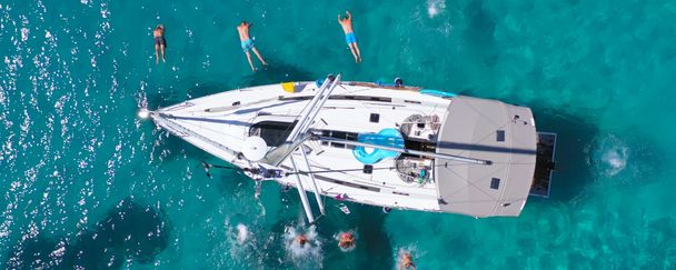 people jumping of a sailboat bird view shot