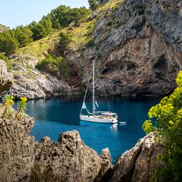 Sailboat anchored in secluded bay in Mallorca