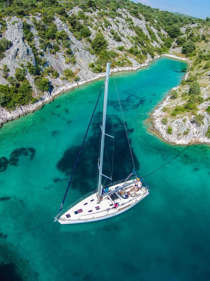 A sailboat acnhord in a secluded bay