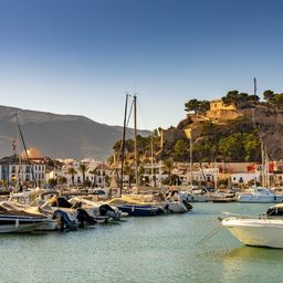 Vista del puerto deportivo y el castillo histórico en la cima de la colina en el casco antiguo de Denia