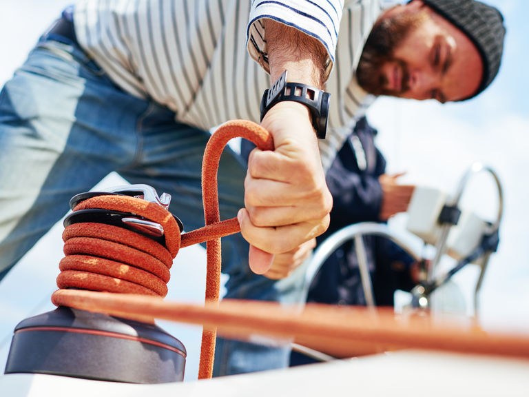 Sailor using a winch on a sailboat