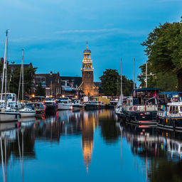 Zicht op het verlichte historische deel van de stad Lemmer in Friesland, Nederland na zonsondergang