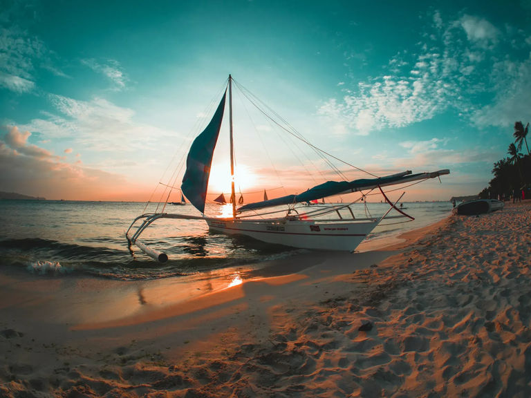 Outrigger boat on a beach with sunset