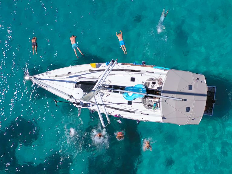 People jumping from a sailboat bird view shot