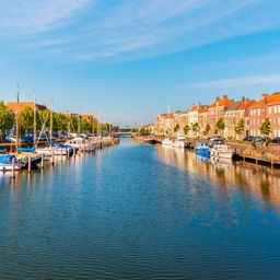 Zeilboot in de Zeeuwse wateren met typisch Nederlandse wolkenlucht